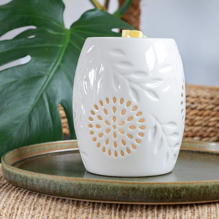 White ceramic wax warmer with delicate leaves design.