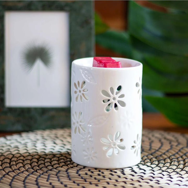 White ceramic wax warmer with delicate floral and leaf cut-out design. 