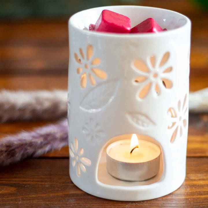 White ceramic wax warmer with delicate floral and leaf cut-out design. 