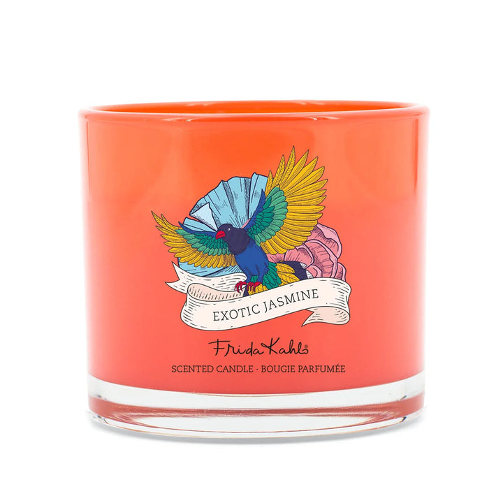 Frida Kahlo Exotic Jasmine scented candle. Bright orange glass candle featuring a colorful bird and floral design with elegant branding on the front.
