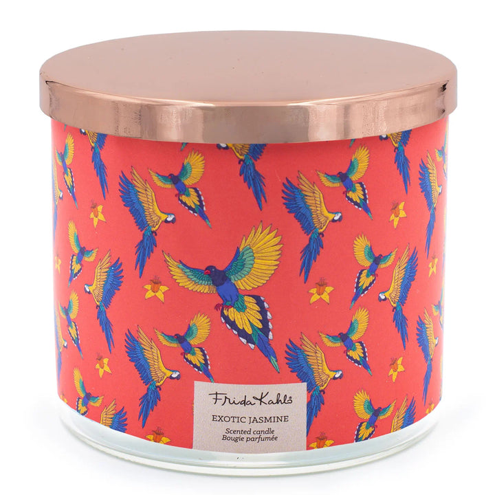 Frida Kahlo “Exotic Jasmine” scented candle with rose-gold lid and vibrant red label featuring colorful parrots and yellow flowers. 