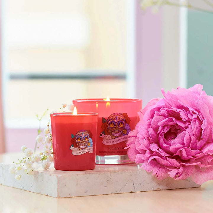 Frida Kahlo Full Moon Mystery scented candle. Vibrant pink glass candle featuring a colorful sugar skull and floral design inspired by Frida Kahlo’s iconic art style.