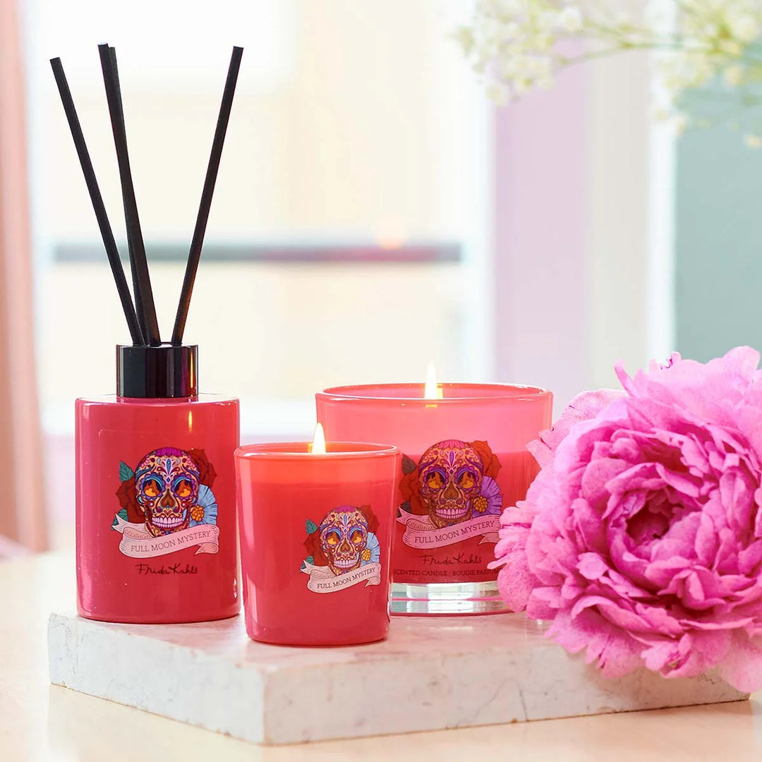 Frida Kahlo Full Moon Mystery scented candle. Vibrant pink glass candle featuring a colorful sugar skull and floral design inspired by Frida Kahlo’s iconic art style.