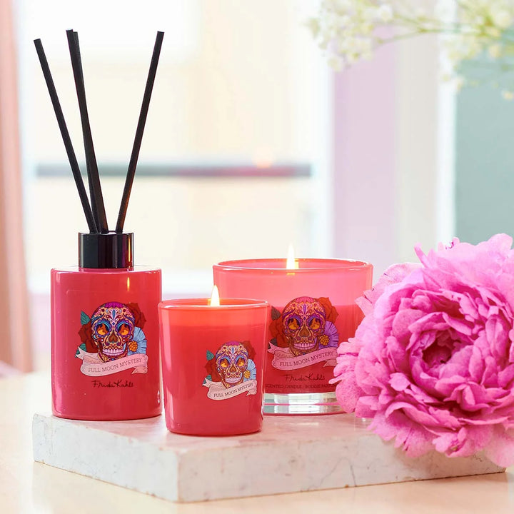 Frida Kahlo Full Moon Mystery scented candle. Vibrant pink glass candle featuring a colorful sugar skull and floral design inspired by Frida Kahlo’s iconic art style.