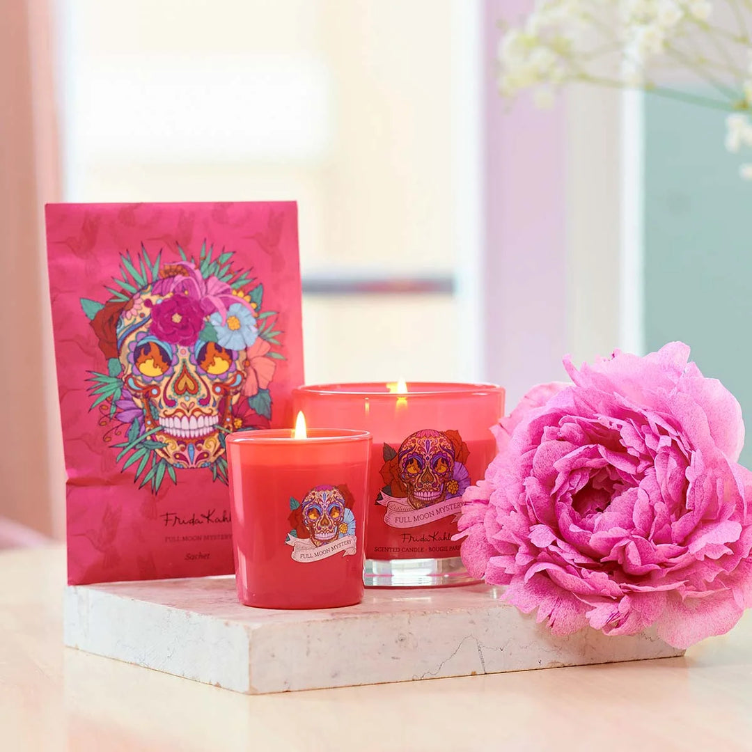 Frida Kahlo Full Moon Mystery scented candle. Vibrant pink glass candle featuring a colorful sugar skull and floral design inspired by Frida Kahlo’s iconic art style.