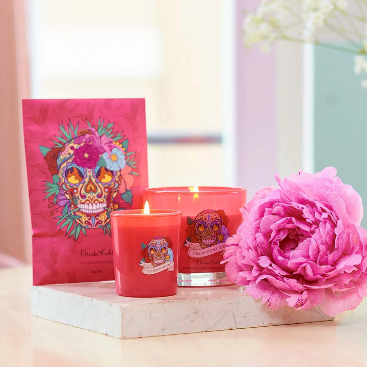 Frida Kahlo Full Moon Mystery scented candle. Vibrant pink glass candle featuring a colorful sugar skull and floral design inspired by Frida Kahlo’s iconic art style.
