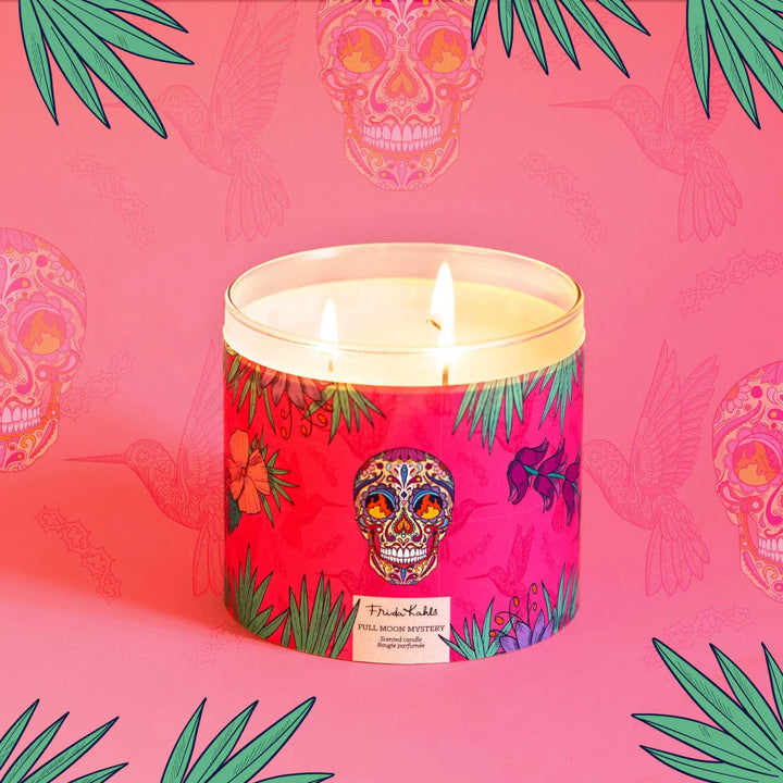 Frida Kahlo “Full Moon Mystery” scented candle with three wicks, featuring a vibrant pink label decorated with tropical leaves, flowers, and a colorful sugar-skull design.