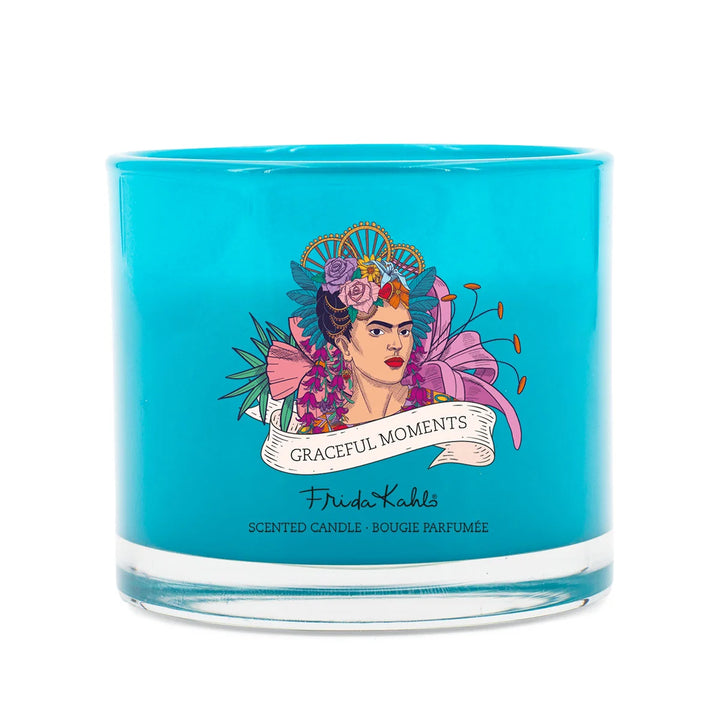Frida Kahlo Graceful Moments scented candle. Turquoise glass candle featuring an artistic portrait of Frida Kahlo surrounded by colorful flowers and elegant branding.