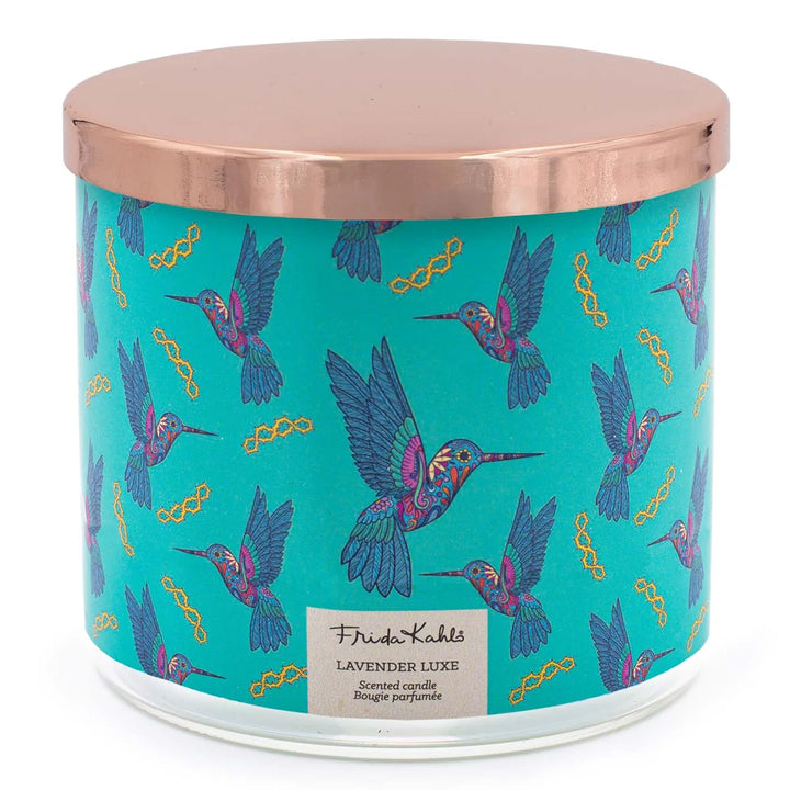 Frida Kahlo “Lavender Luxe” scented candle with a rose-gold lid and turquoise label decorated with colorful hummingbirds. 