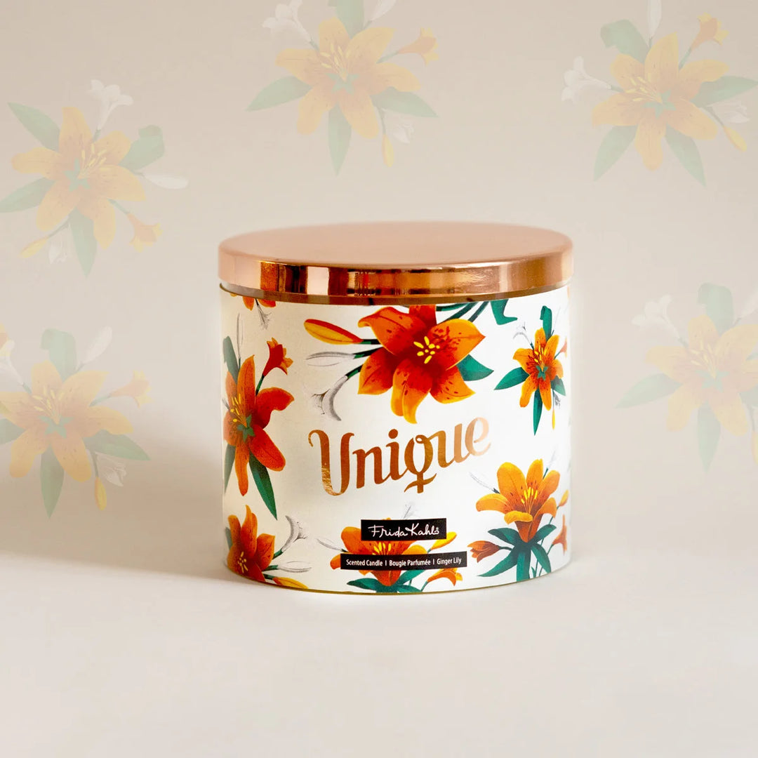 Frida Kahlo “Unique” scented candle with a rose-gold lid and floral ginger lily design. Decorative premium candle featuring vibrant orange lilies, perfect for home fragrance, gifting, and stylish interior décor.