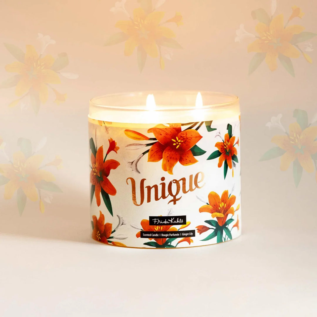 Frida Kahlo “Unique” scented candle with a rose-gold lid and floral ginger lily design. Decorative premium candle featuring vibrant orange lilies, perfect for home fragrance, gifting, and stylish interior décor.