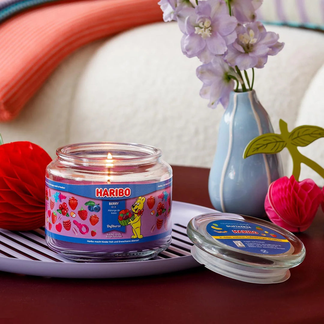 Haribo Berry Mix Scented Candle in glass jar with lit wick, purple wax and berries design label