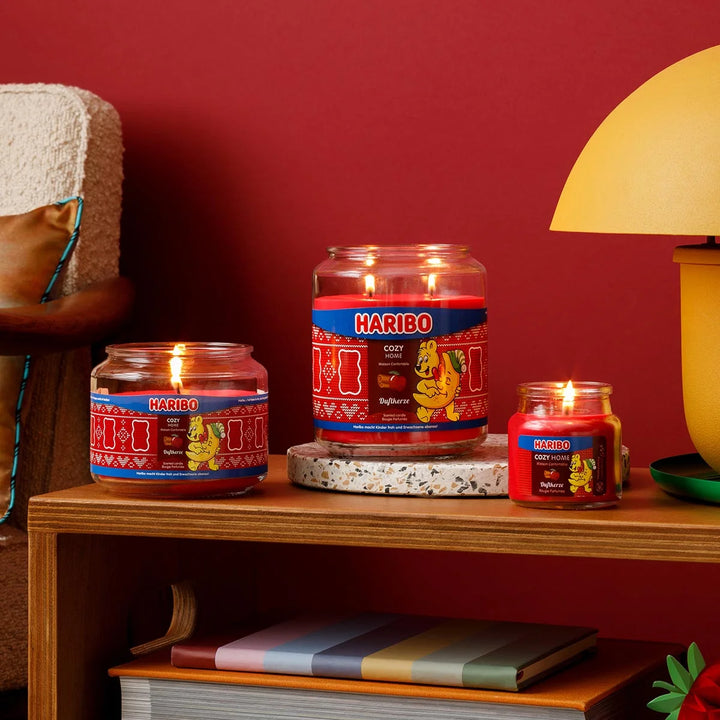 HARIBO Cozy Home scented candle – red jar candle decorated with apple, cinnamon, and the cheerful HARIBO bear holding a moon.