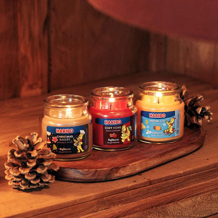 HARIBO Cozy Home scented candle – red jar candle decorated with apple, cinnamon, and the cheerful HARIBO bear holding a moon.