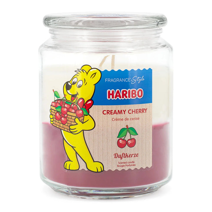 HARIBO Creamy Cherry scented candle in a glass jar with white and red wax featuring the Haribo bear holding a basket of cherries.